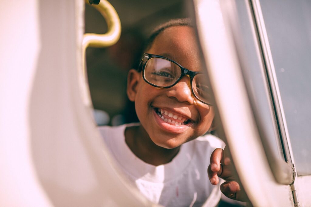 Young boy peaking through window smiling - autism diagnosis