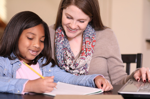 Foster care mother helping daughter write