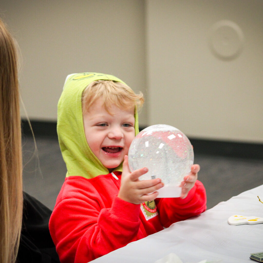 boy with autism holding snow globe